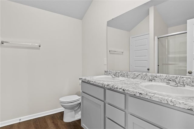 bathroom featuring vanity, a shower with door, vaulted ceiling, toilet, and wood-type flooring