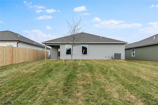 back of house with central AC and a lawn