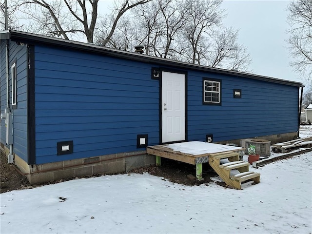 snow covered property with cooling unit