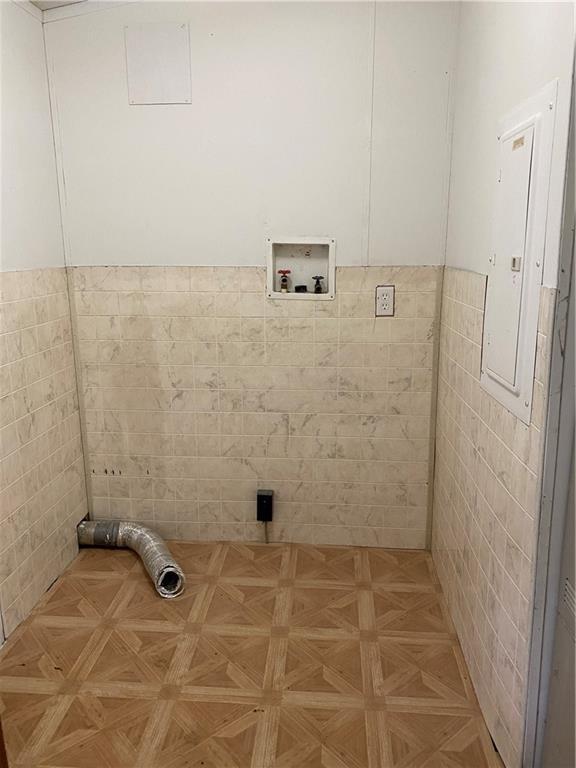 738 Pacific Ave, Osawatomie, KS 66064 - clothes washing area featuring tile walls, hookup for a washing machine, wainscoting, and laundry area
