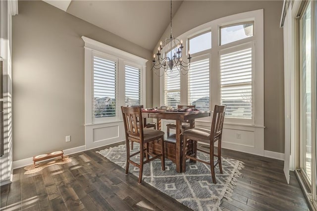 dining space with lofted ceiling, dark wood-type flooring, and a chandelier