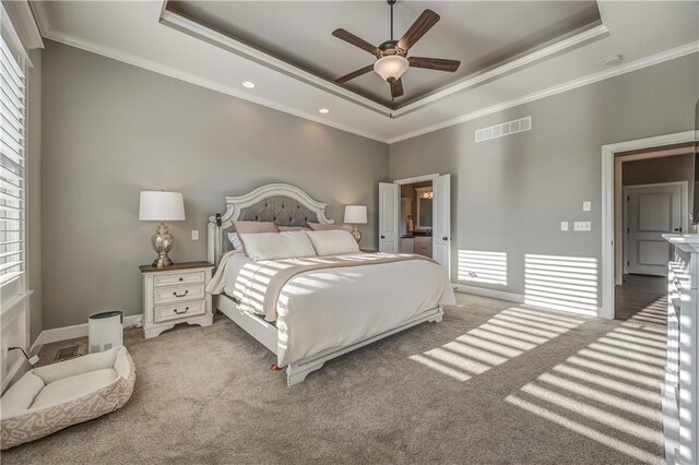 carpeted bedroom featuring ceiling fan, a raised ceiling, and ornamental molding