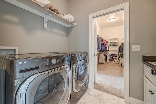 clothes washing area with light carpet and washer and dryer