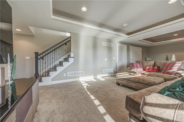 living room with carpet floors and a tray ceiling