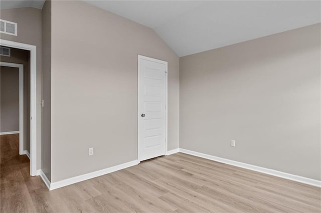 unfurnished bedroom with light wood-type flooring and vaulted ceiling