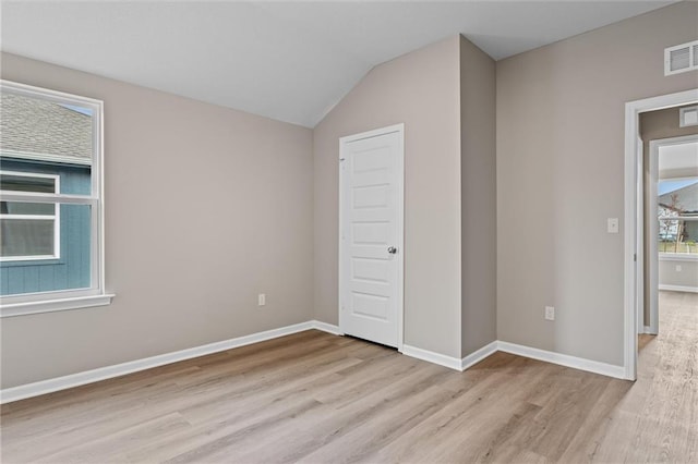 unfurnished bedroom featuring light hardwood / wood-style floors and vaulted ceiling