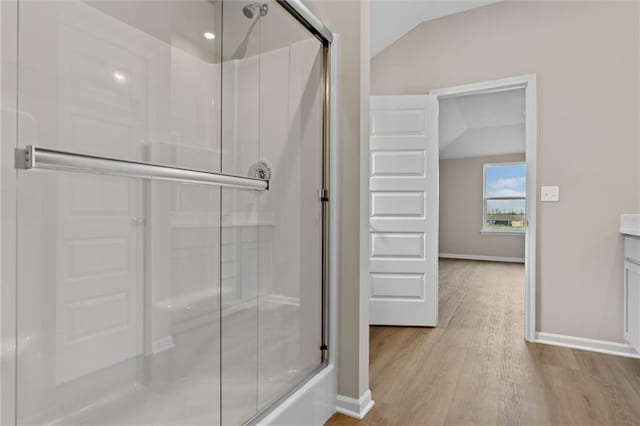 bathroom with hardwood / wood-style floors, vanity, and lofted ceiling