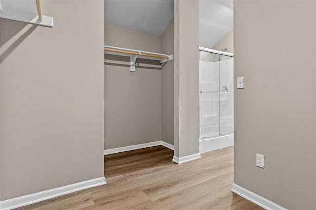 walk in closet with light hardwood / wood-style floors