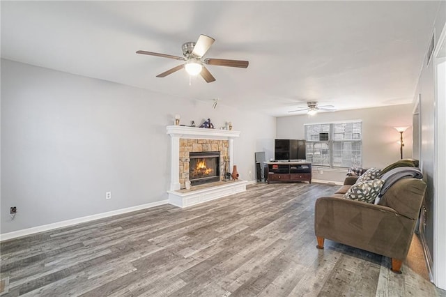 living room featuring a fireplace, wood-type flooring, and ceiling fan