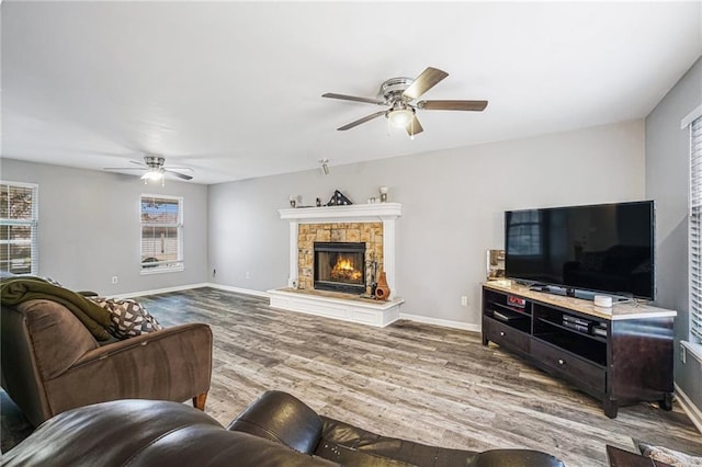 living room with a fireplace, wood-type flooring, and ceiling fan