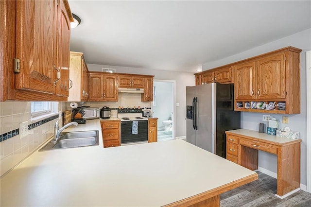 kitchen with sink, tasteful backsplash, dark hardwood / wood-style flooring, kitchen peninsula, and white appliances