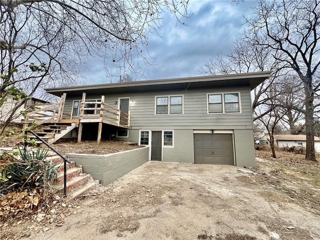 rear view of property with a garage and a deck