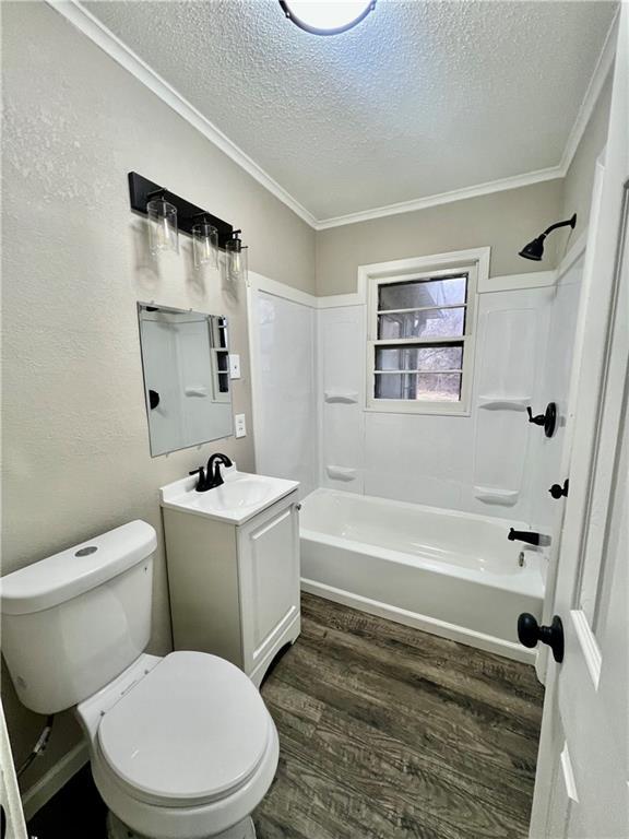 full bathroom with toilet, vanity, wood-type flooring, and ornamental molding