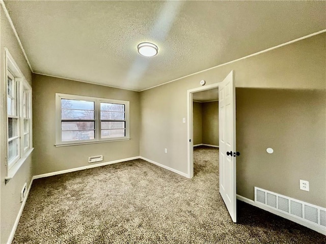 spare room featuring carpet flooring and a textured ceiling