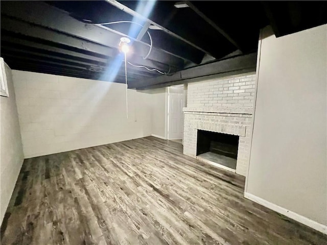 basement with hardwood / wood-style floors and a brick fireplace