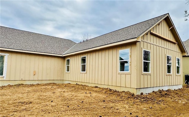 view of home's exterior featuring board and batten siding and roof with shingles