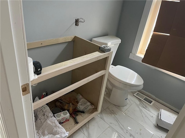 half bathroom featuring visible vents, marble finish floor, and toilet
