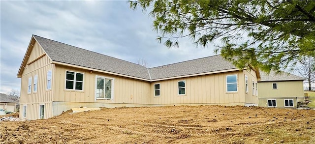 back of house featuring a shingled roof