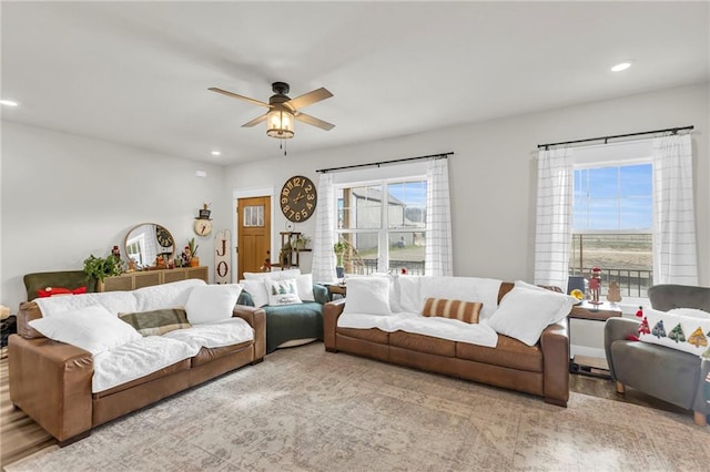 living room featuring ceiling fan, light hardwood / wood-style flooring, and a healthy amount of sunlight