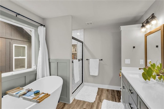 bathroom featuring hardwood / wood-style floors, vanity, and shower with separate bathtub