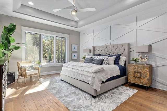 21359 W 93rd Ct, Lenexa, KS 66220 - bedroom with a raised ceiling, wood finished floors, baseboards, a skylight, and a ceiling fan