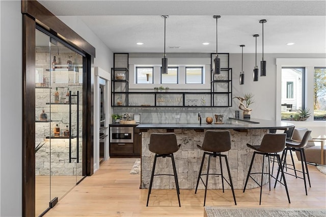 21359 W 93rd Ct, Lenexa, KS 66220 - bar featuring plenty of natural light, light wood-type flooring, tasteful backsplash, hanging light fixtures, and recessed lighting