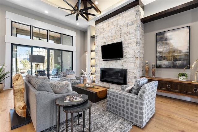 21359 W 93rd Ct, Lenexa, KS 66220 - living room featuring light wood-style flooring, a stone fireplace, recessed lighting, ceiling fan, and a towering ceiling