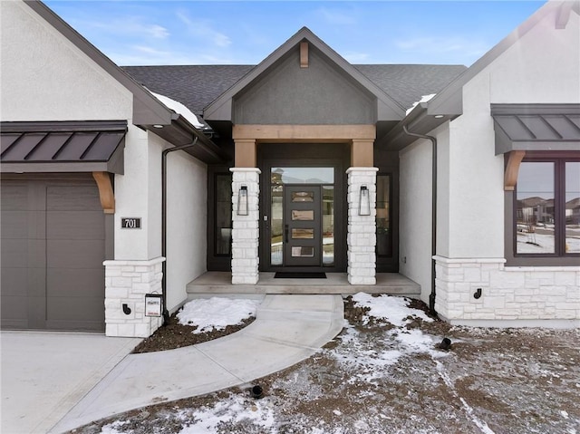 snow covered property entrance with a garage