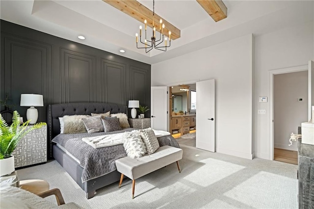 carpeted bedroom with a high ceiling, ensuite bathroom, beamed ceiling, and an inviting chandelier