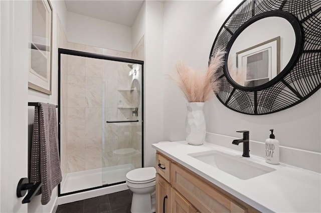 bathroom featuring tile patterned floors, toilet, a shower with door, and vanity