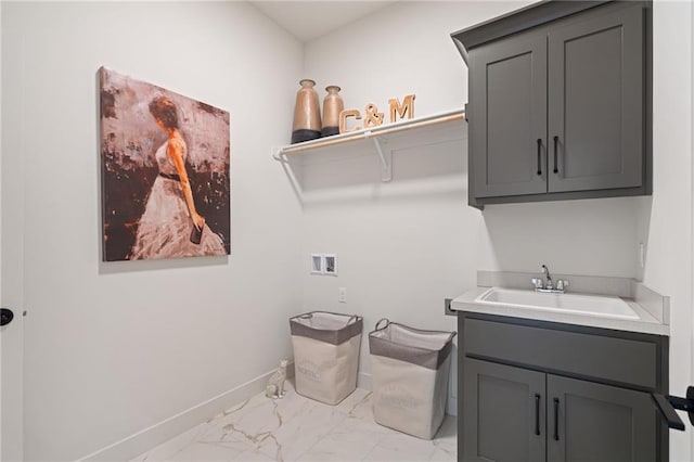 clothes washing area featuring sink, hookup for a washing machine, and cabinets