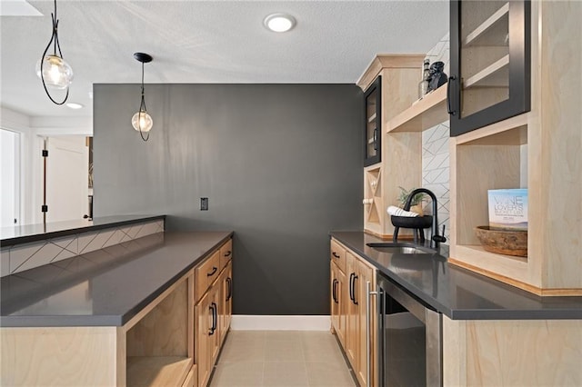 kitchen featuring a textured ceiling, pendant lighting, wine cooler, and sink