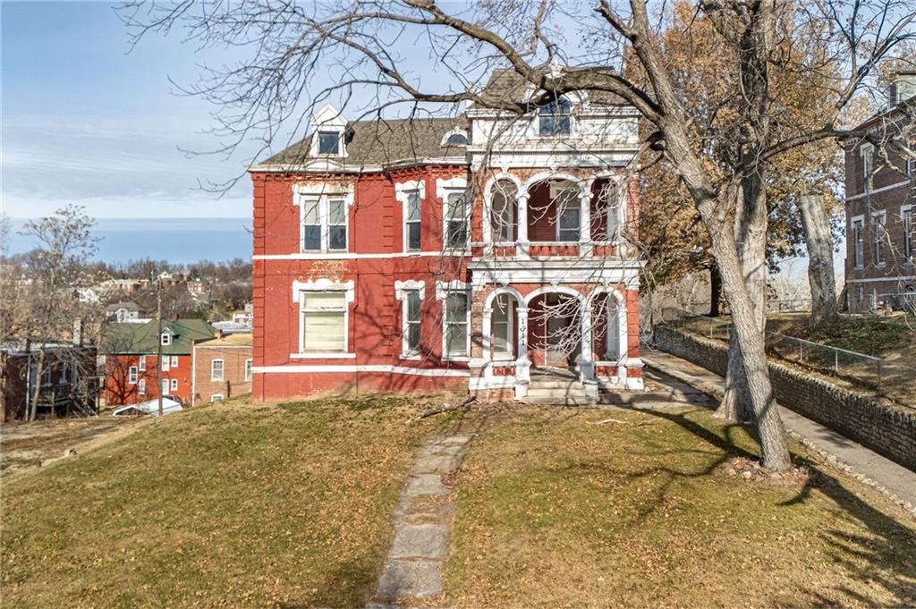 view of front of home featuring a balcony and a front lawn