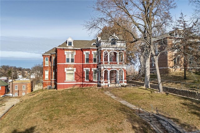 view of front of property with a balcony and a front yard