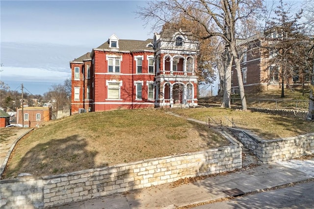 view of front of house featuring a balcony and a front lawn