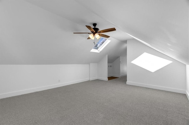 additional living space with lofted ceiling with skylight, carpet flooring, ceiling fan, and baseboards