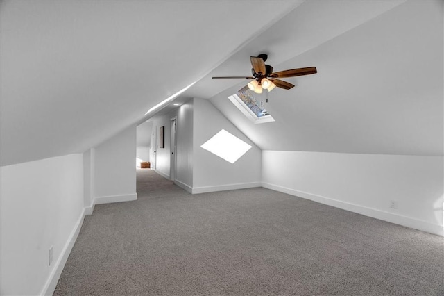 bonus room featuring ceiling fan, lofted ceiling with skylight, carpet, and baseboards