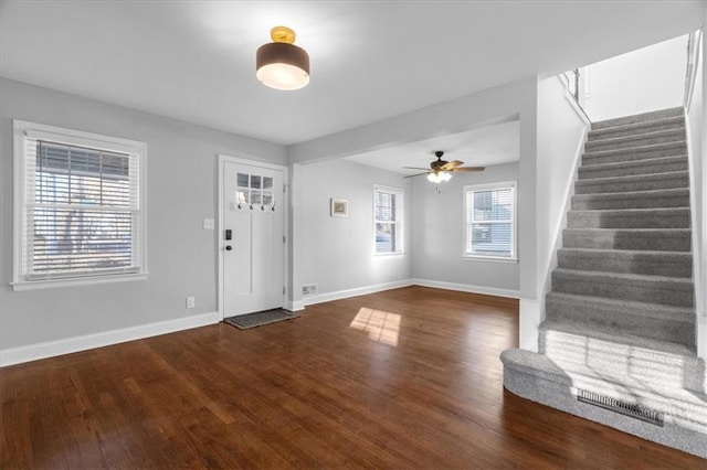 entrance foyer featuring visible vents, stairway, a ceiling fan, wood finished floors, and baseboards