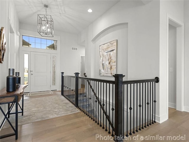 entrance foyer with hardwood / wood-style floors and a notable chandelier