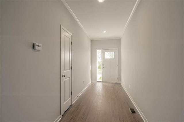 doorway featuring crown molding and hardwood / wood-style floors