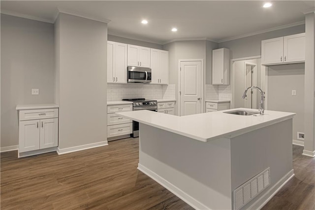 kitchen with dark hardwood / wood-style flooring, stainless steel appliances, a kitchen island with sink, sink, and white cabinetry