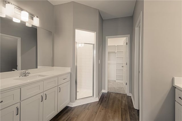 bathroom featuring a shower with shower door, wood-type flooring, and vanity