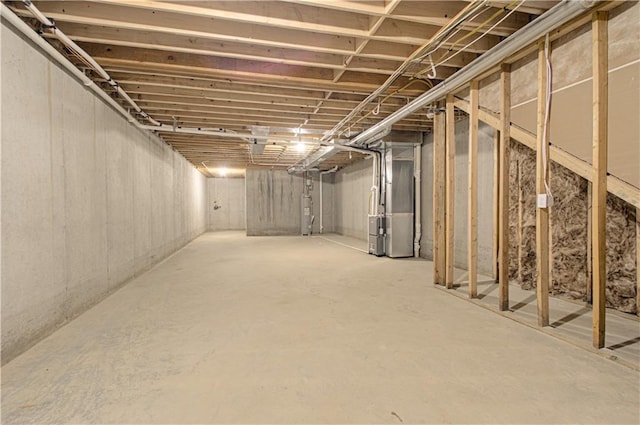 basement with electric water heater and heating unit