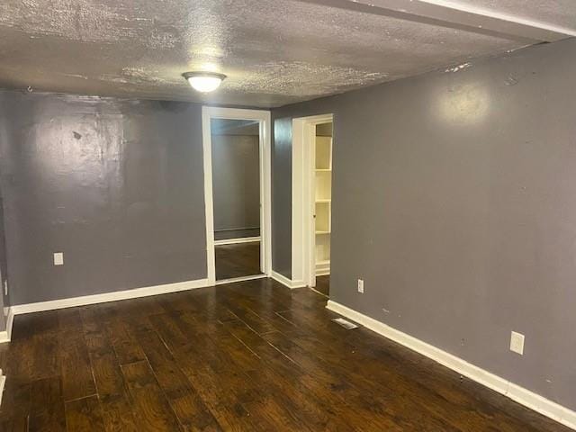 empty room featuring dark hardwood / wood-style flooring and a textured ceiling