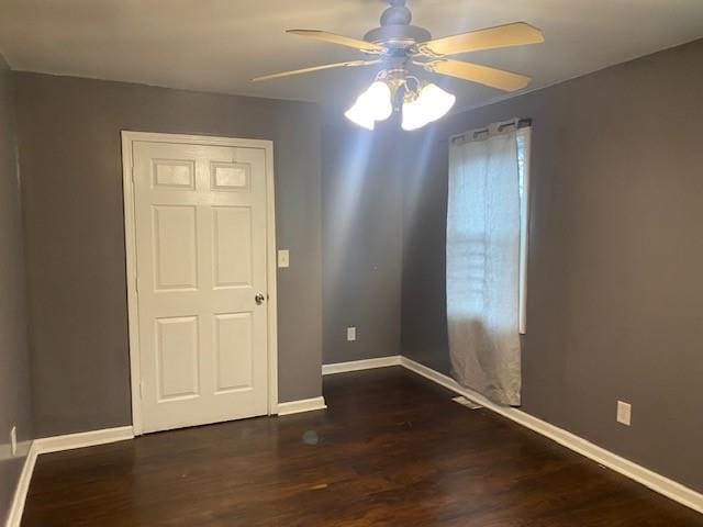 spare room featuring ceiling fan and dark wood-type flooring