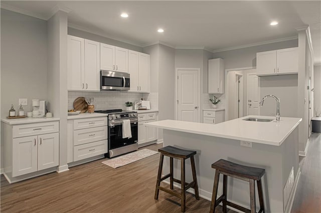 kitchen featuring appliances with stainless steel finishes, white cabinetry, dark wood-type flooring, and sink