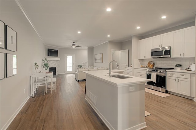 kitchen with sink, white cabinets, a center island with sink, and appliances with stainless steel finishes