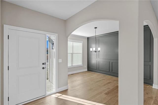 foyer entrance featuring light hardwood / wood-style floors and an inviting chandelier