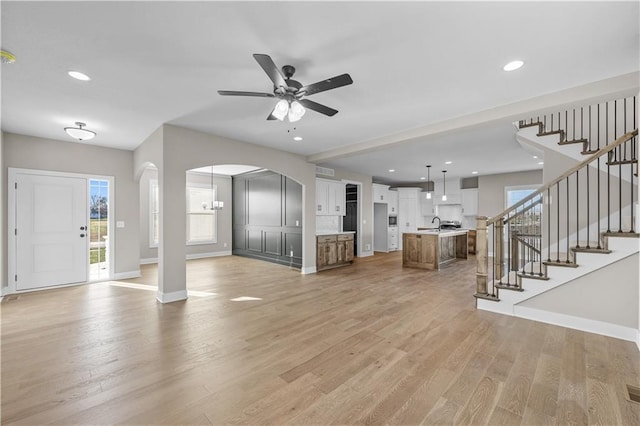 unfurnished living room featuring ceiling fan and light wood-type flooring