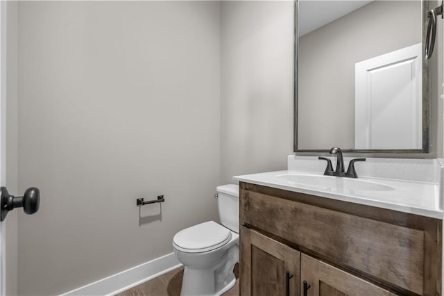 bathroom with hardwood / wood-style floors, vanity, and toilet